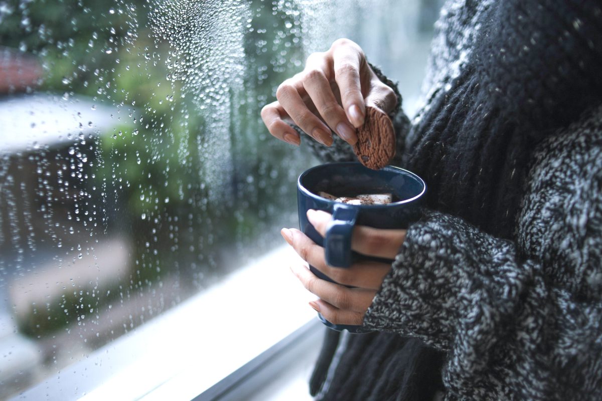close up hands warm knitted wear dipping cookie hot coffee by window with raindrop scaled 1 large