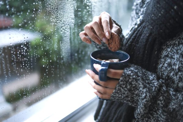 close up hands warm knitted wear dipping cookie hot coffee by window with raindrop scaled 1 medium